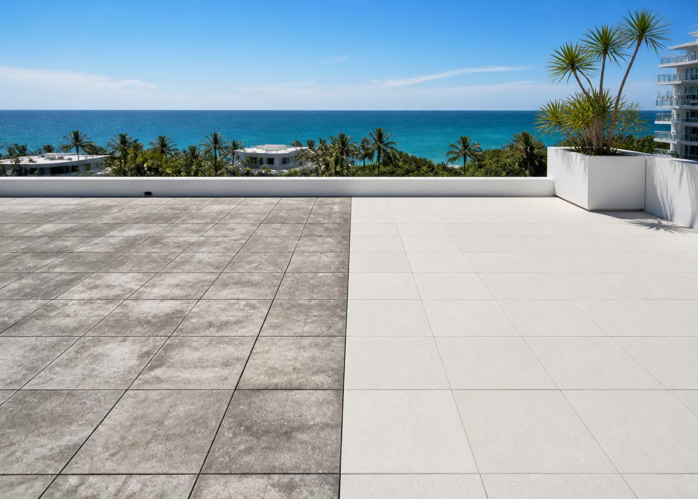 Rooftop terrace with aged gray concrete pavers on one side and renewed light mineral-finish pavers on the other, overlooking the ocean